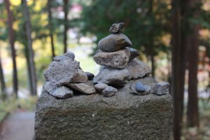 Close up of a collection of small rocks arranged on top of a stone post.