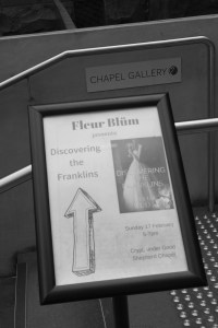 Black and white. A sign points to a book launch.