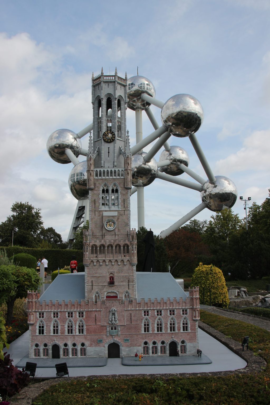 A miniature version of a building stands in front of the Atomium in Brussels.